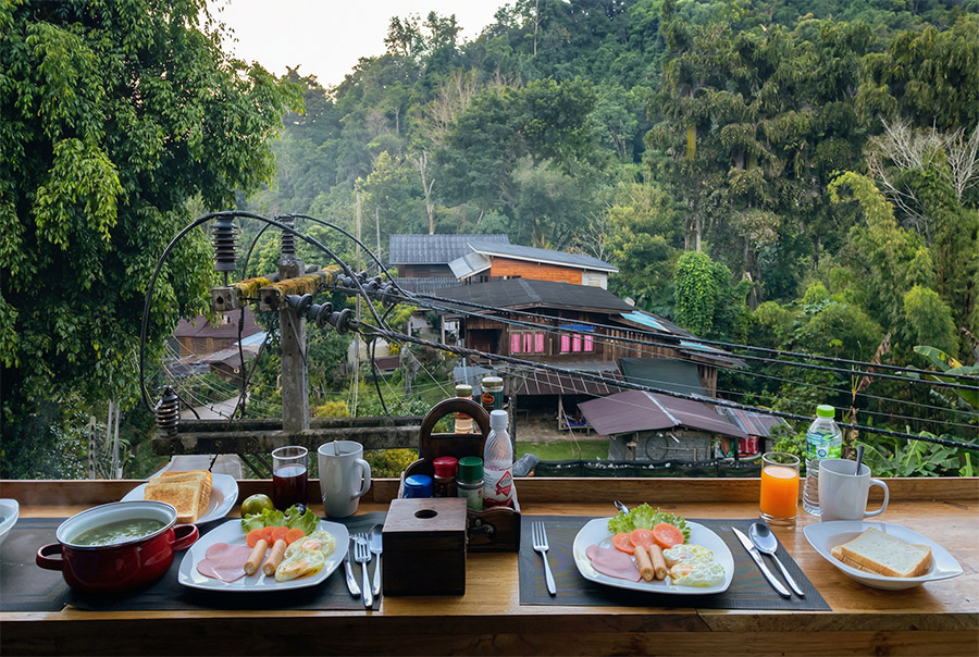 Breakfast table at Villa Vadee with a panorama view over Mae Kampong village and green forested mountains
